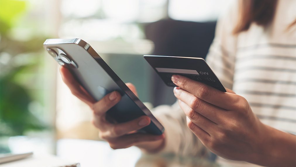 Person holding a new cell phone and a credit card